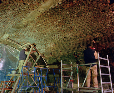 840194 Afbeelding van de restauratie van de boogmuur onder de Bijlhouwerbrug over de Oudegracht te Utrecht.
